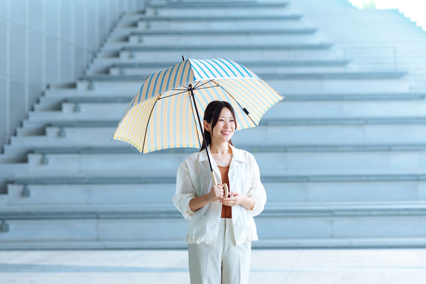 ストライプ柄のレディース傘を差す女性
