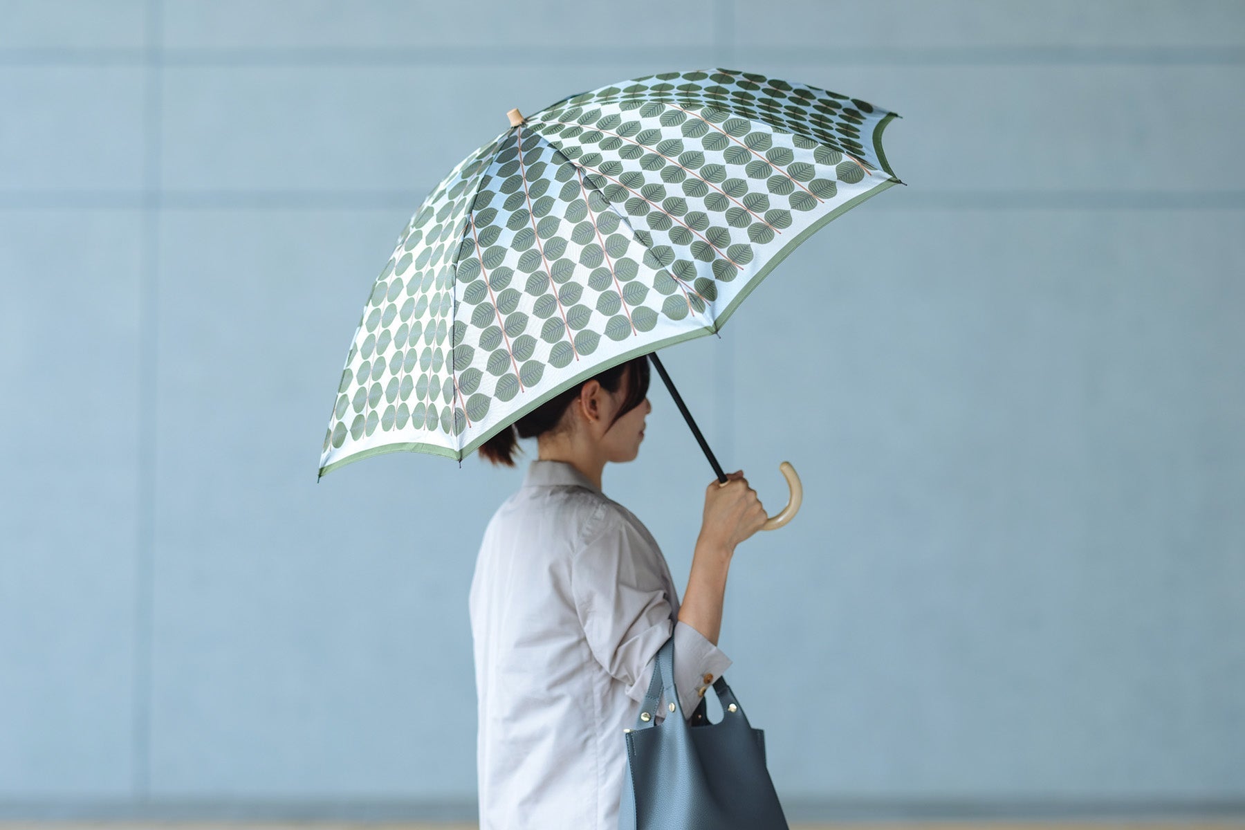 リンドベリ柄のレディース折りたたみ傘を持つ女性