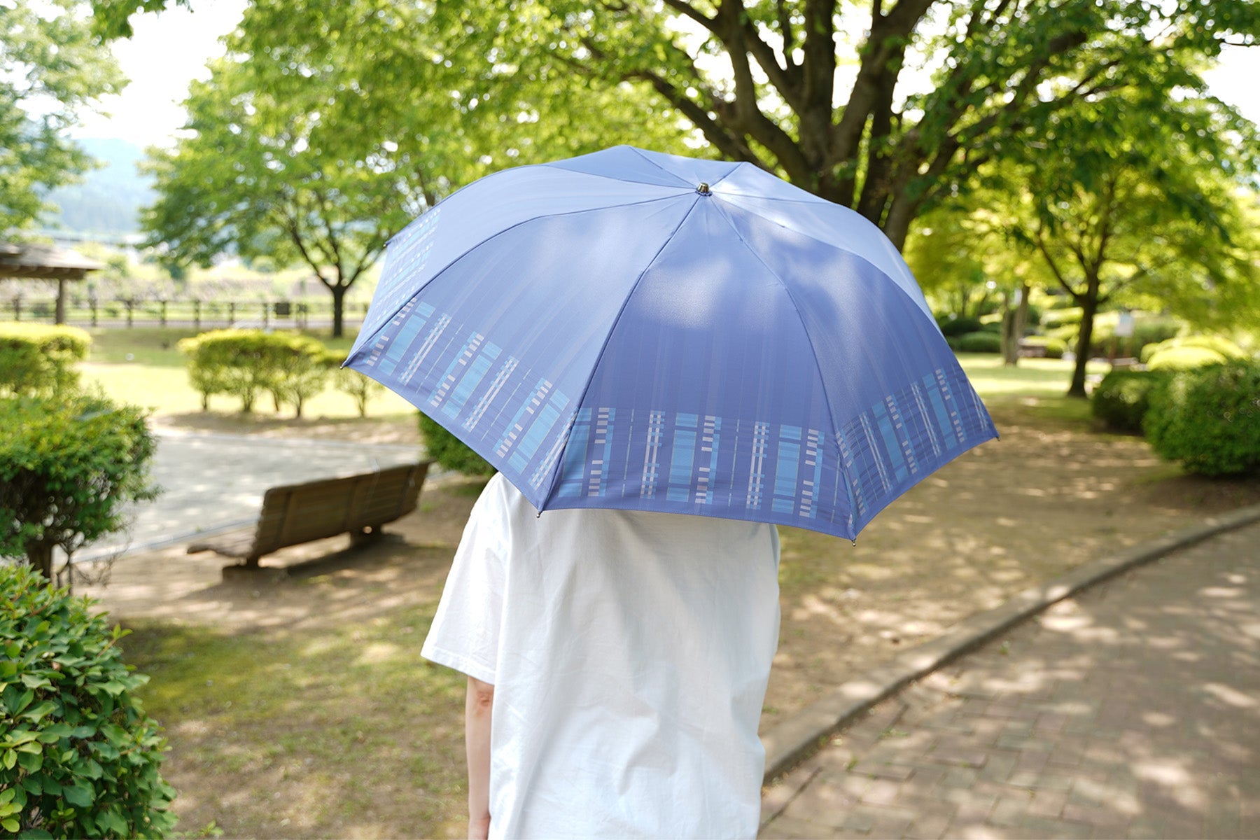 遮熱糸を使った先染織物の晴雨兼用日傘を差す女性