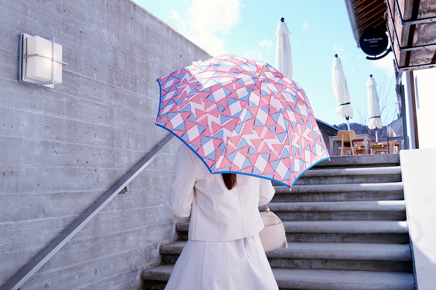 青、ピンク、白の晴雨兼用日傘を差す女性