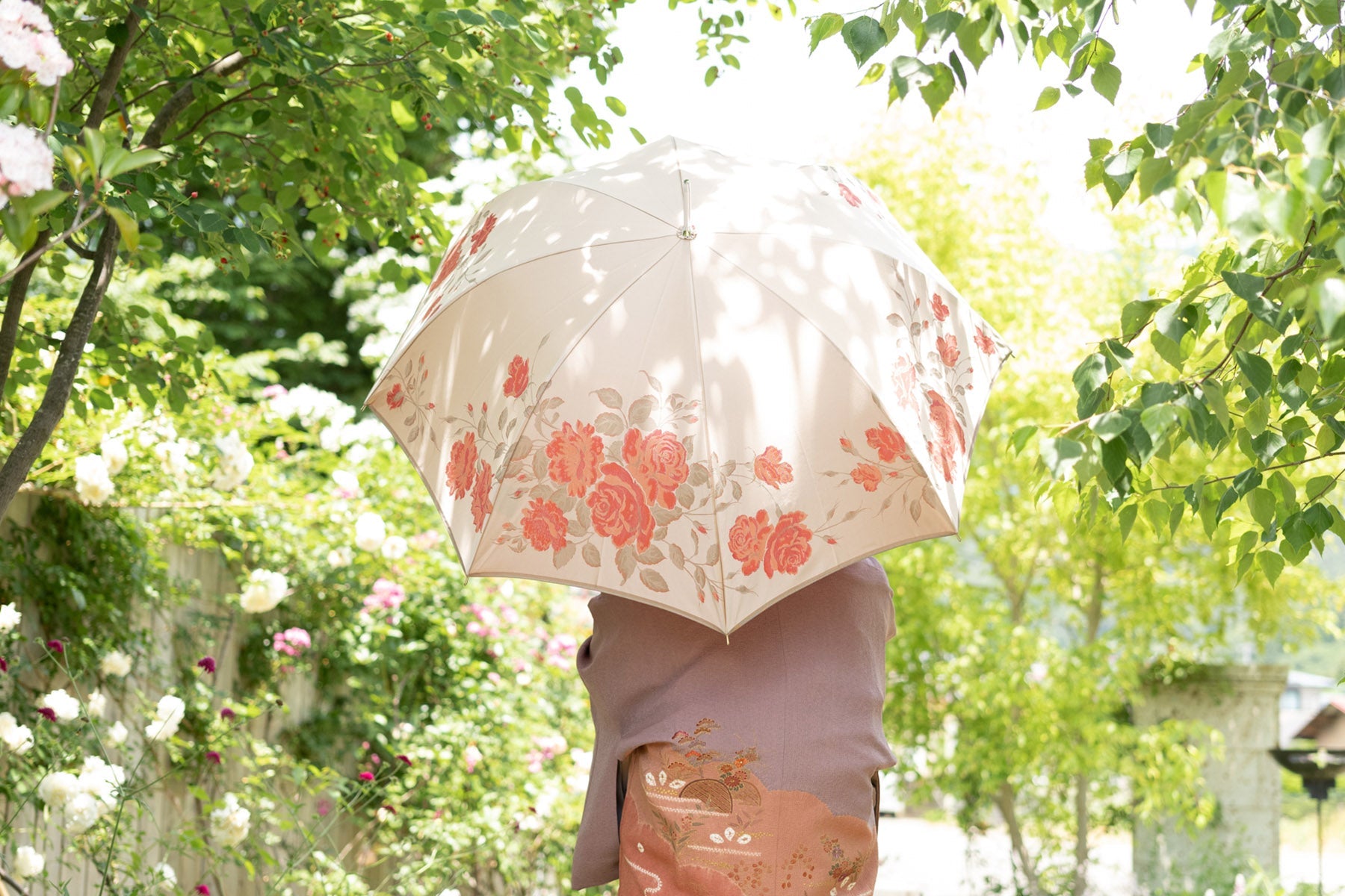 薔薇柄の傘を差す女性