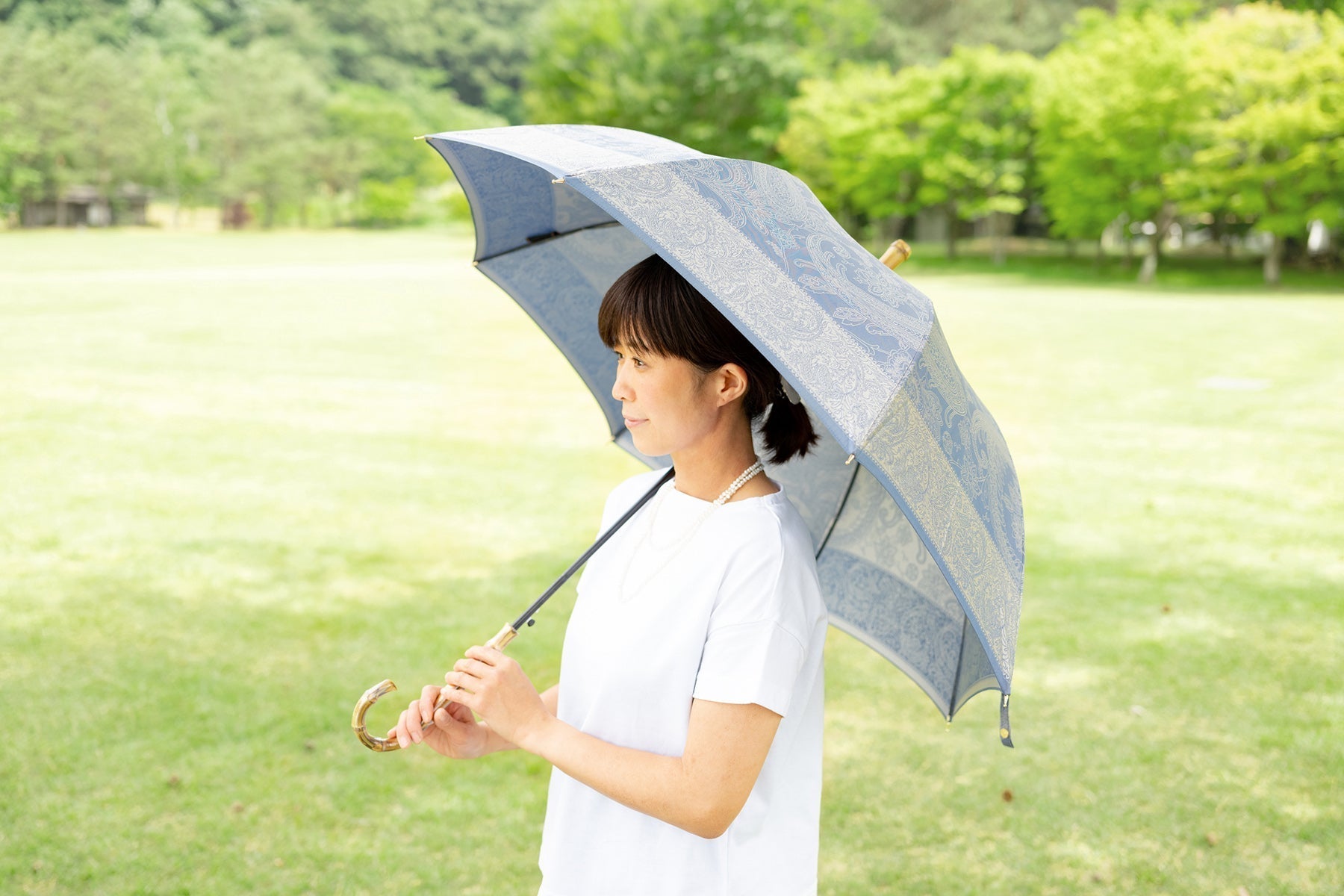 ブルーのペイズリー柄のレディース傘を差す女性