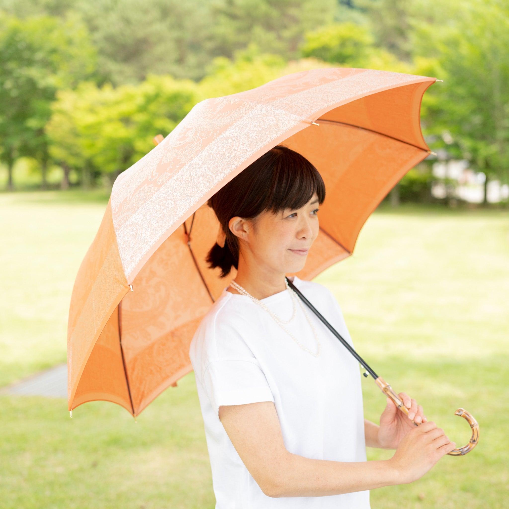 晴雨兼用 レディース kirie ペイズリー ビンテージアプリコット 長傘 使用イメージ