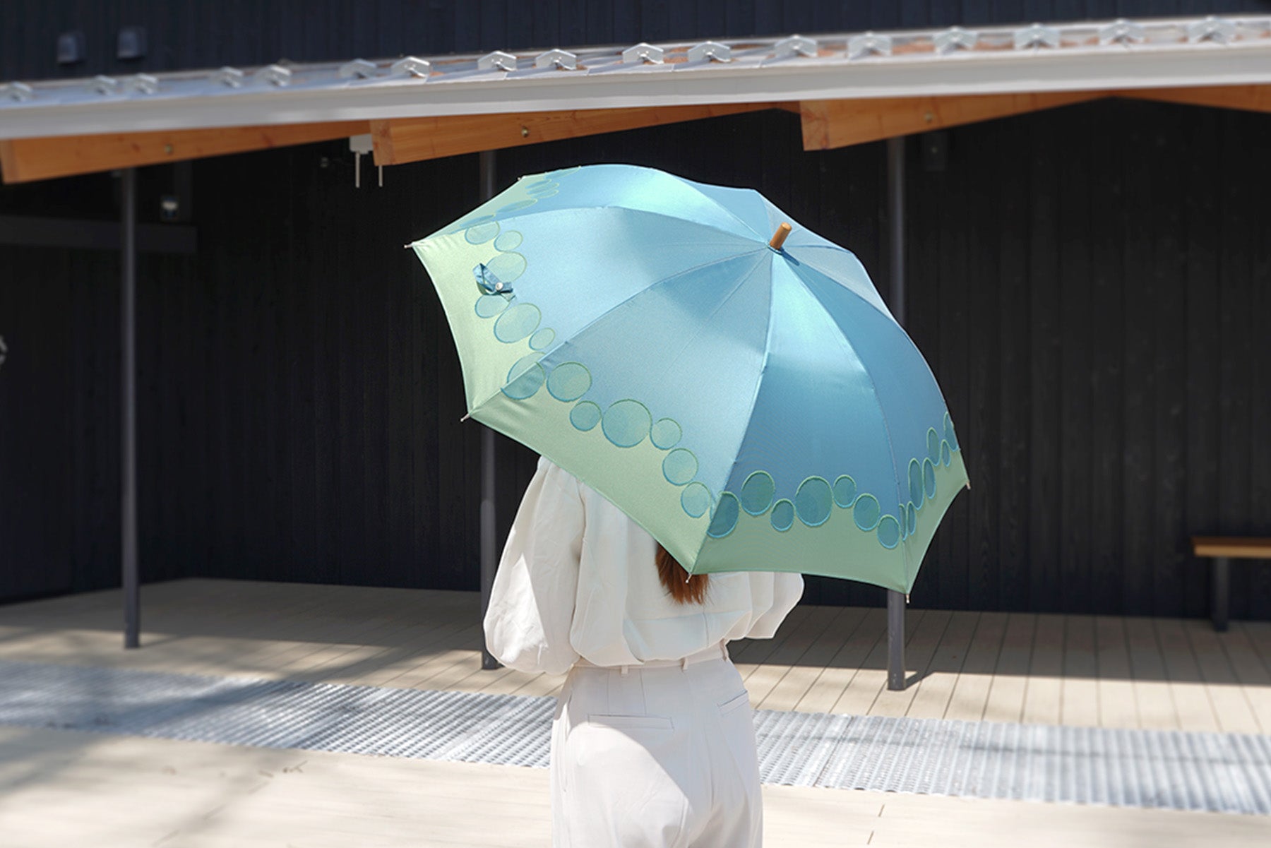 グリーンの晴雨兼用レディース傘を差す女性