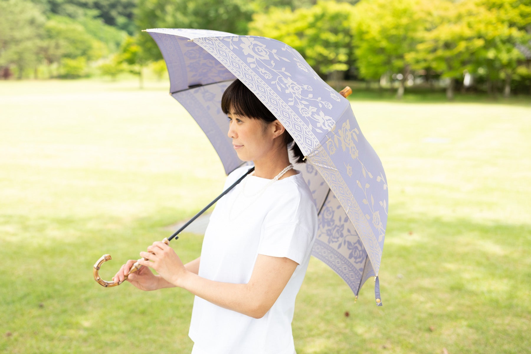 薄紫色のバラ柄のレディース傘を差す女性